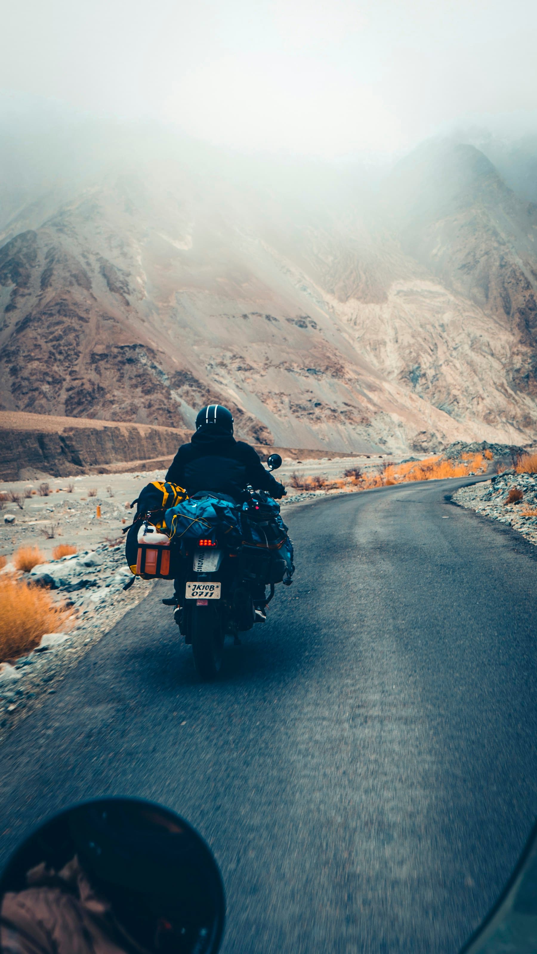 Motociclist pe o motocicletă adventure într-un pas montan