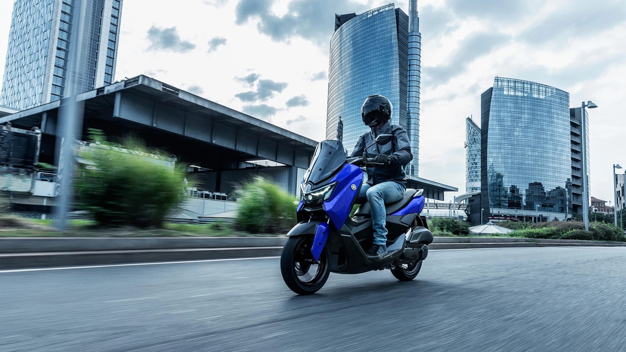 Yamaha NMAX 125 albastru rulând pe o șosea de coastă