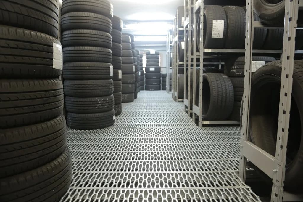 Depozit de anvelope pe rafturi metalice, cu etichete de inventar pe flancuri