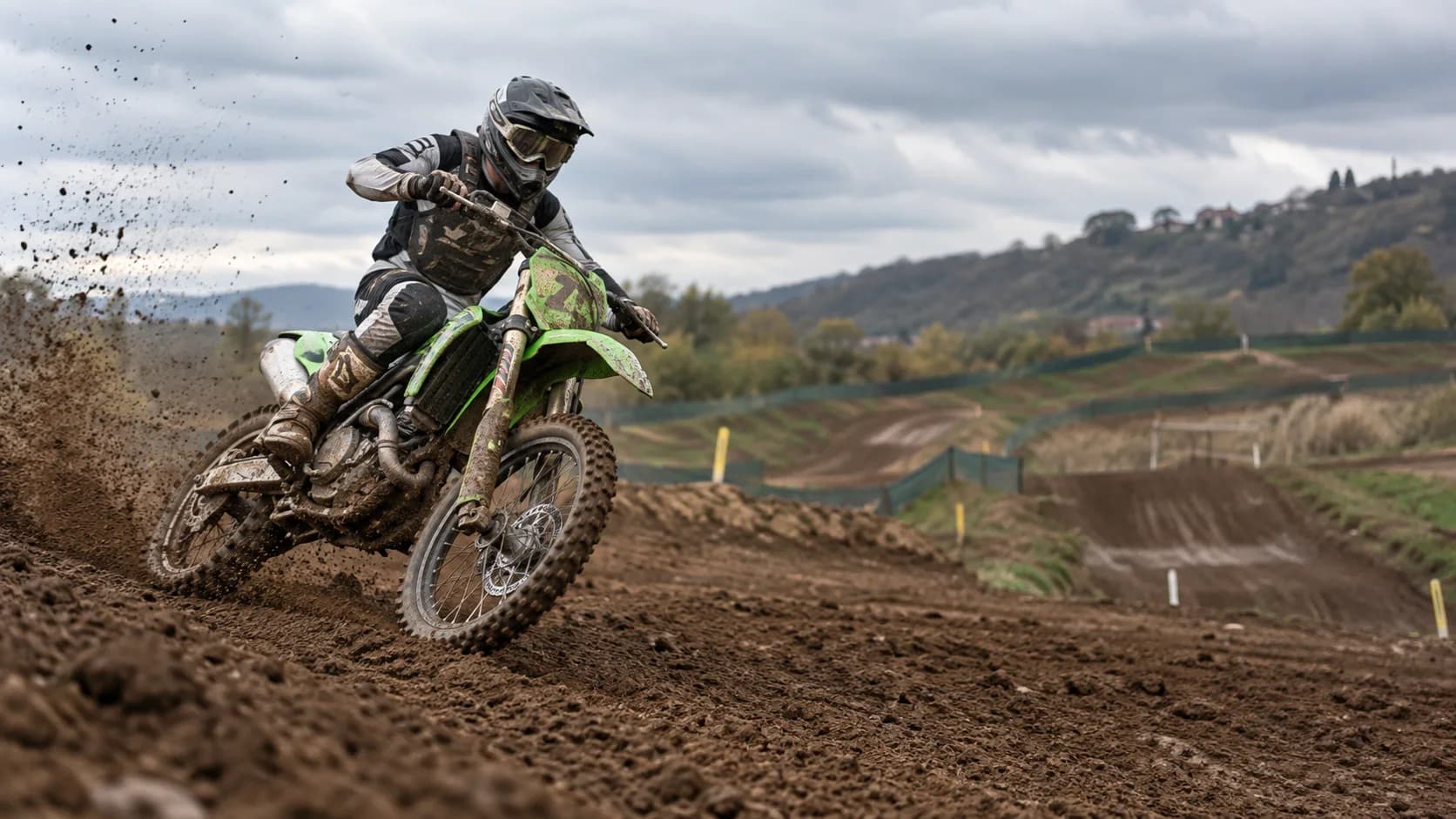 motocicletă de motocross verde pe circuit de pământ umed, fără sigle vizibile